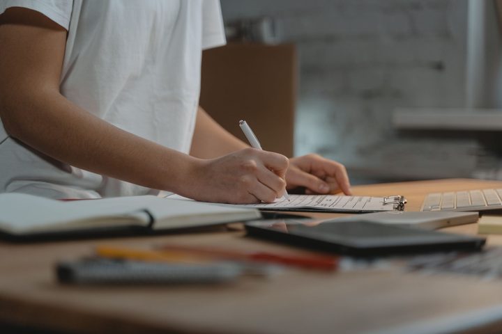 紙に書き込んでいる手元